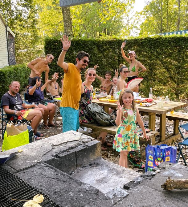 Holidaymakers gather in the picnic area around the barbecue